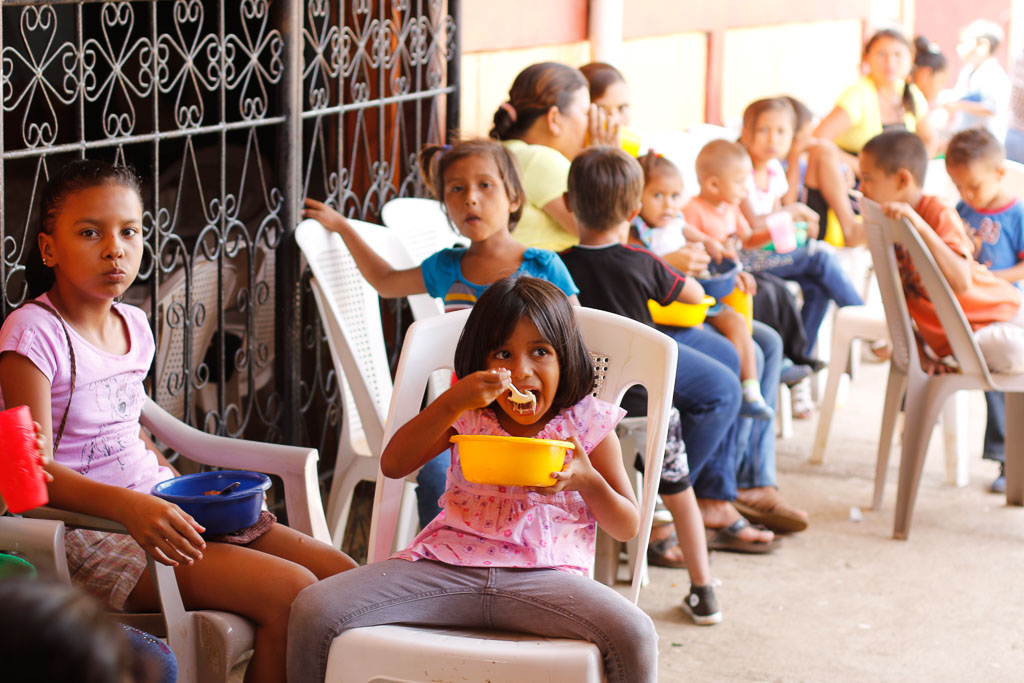Young girl eating lunch at Los Cedros community feeding program